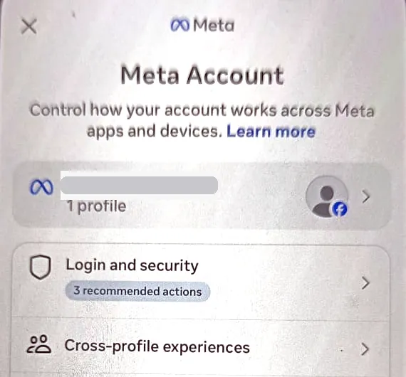 The Meta Account screen on iPhone, with the account’s profile row (phone number hidden), then Login and security marked with 3 recommended actions, and Cross-profile experiences.